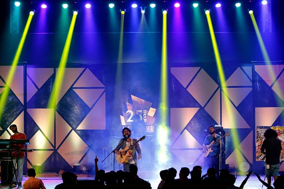 Crowd enjoying a live concert with colorful stage lights, energetic music, raised hands, and an exciting festival atmosphere, representing concert event captions and unforgettable live music experiences.