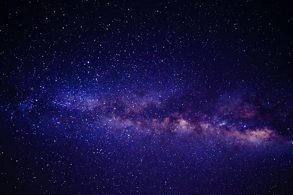 Dreamy aesthetic galaxy with glowing stars, colorful nebula clouds, and a stunning cosmic night sky above a mountain landscape.